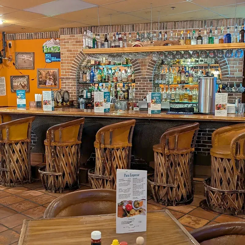 Bottles shelved in a brick arch above the bar, with stools along the counter